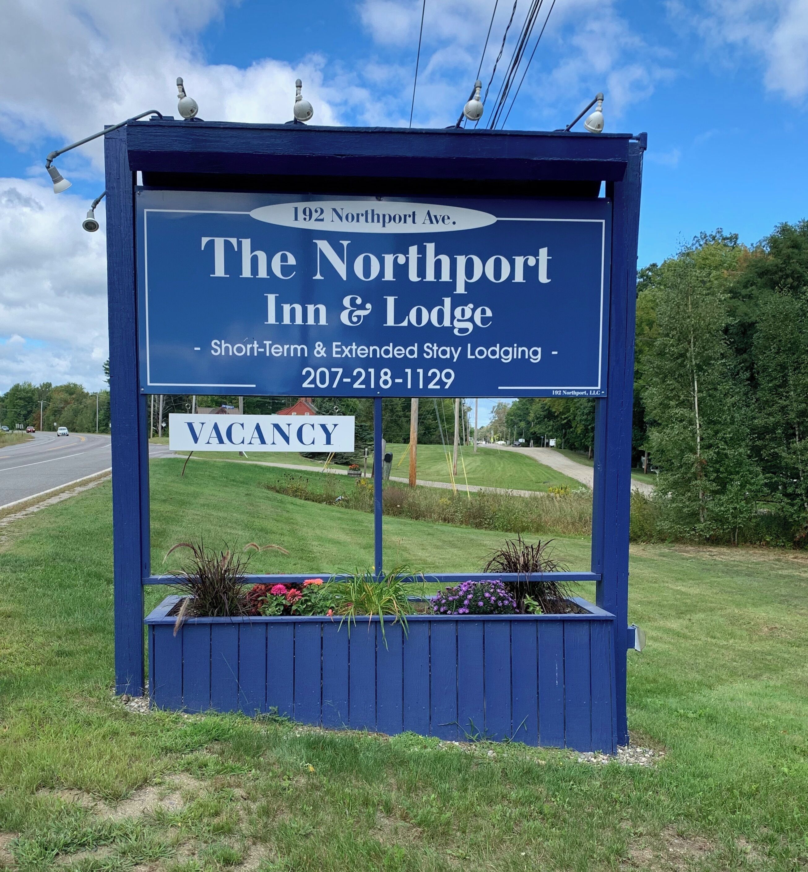A blue sign for The Northport Inn & Lodge advertising short-term and extended stay lodging with a vacancy notice.