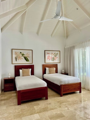 A hotel room with two beds, a ceiling fan, and artwork on the walls. - Luxury Golf Villa in Exclusive Punta Cana Resort (Punta Cana)