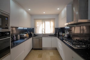 A modern kitchen with stainless steel appliances, a dishwasher, and a gas stove. - Luxury Golf Villa in Exclusive Punta Cana Resort (Punta Cana)