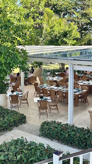 An outdoor dining area with wicker furniture and a covered section. - Luxury Golf Villa in Exclusive Punta Cana Resort (Punta Cana)