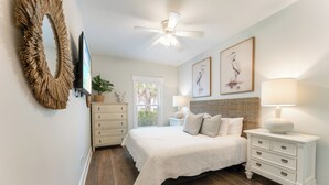 Une chambre à coucher avec un lit, une commode et un ventilateur de plafond.