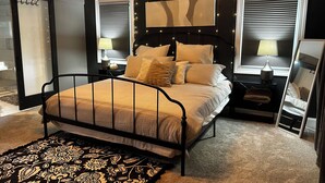 Una camera da letto con un letto, comodini, un tappeto e una testiera decorata con luci a stringa.