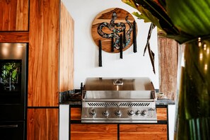 Une cuisine équipée d’une cuisinière en acier inoxydable, de meubles de rangement en bois et d’une décoration murale.