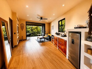Una cocina moderna con un refrigerador grande, armarios de madera y un comedor con mesa y sillas.