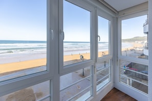 Habitació amb finestres grans que donen a una platja.