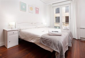 Ein Schlafzimmer mit Bett, Nachttisch und einem Fenster mit Vorhängen.