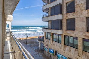 Een gebouw aan het strand met balkons met uitzicht op de oceaan.
