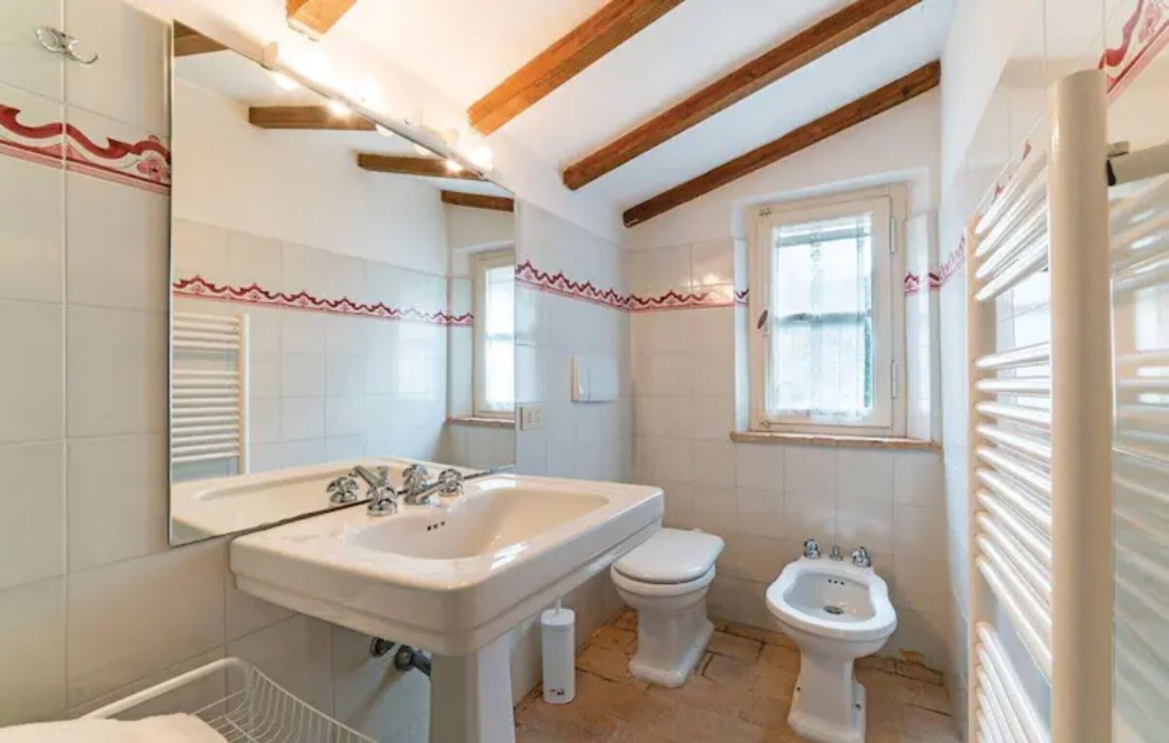 Une salle de bain équipée d’un lavabo, de toilettes, d’un bidet et d’un miroir.