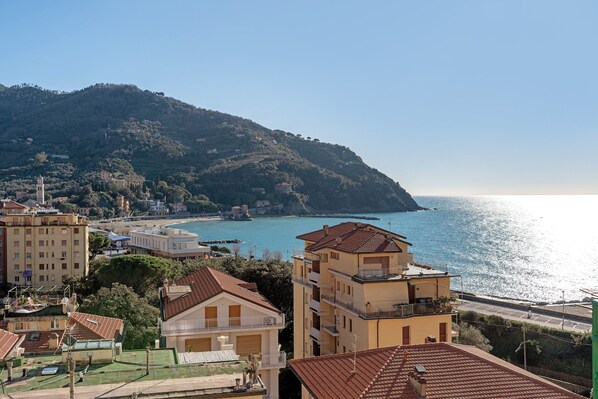 Une ville côtière avec des bâtiments, une colline et une vue sur la mer.