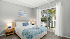 A bedroom with a bed, nightstands, a painting, and a balcony with curtains.