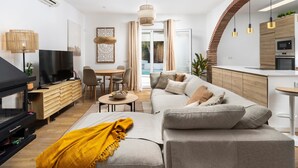 Ein modernes Wohnzimmer mit einer Couch, einem Fernseher und einem Essbereich.