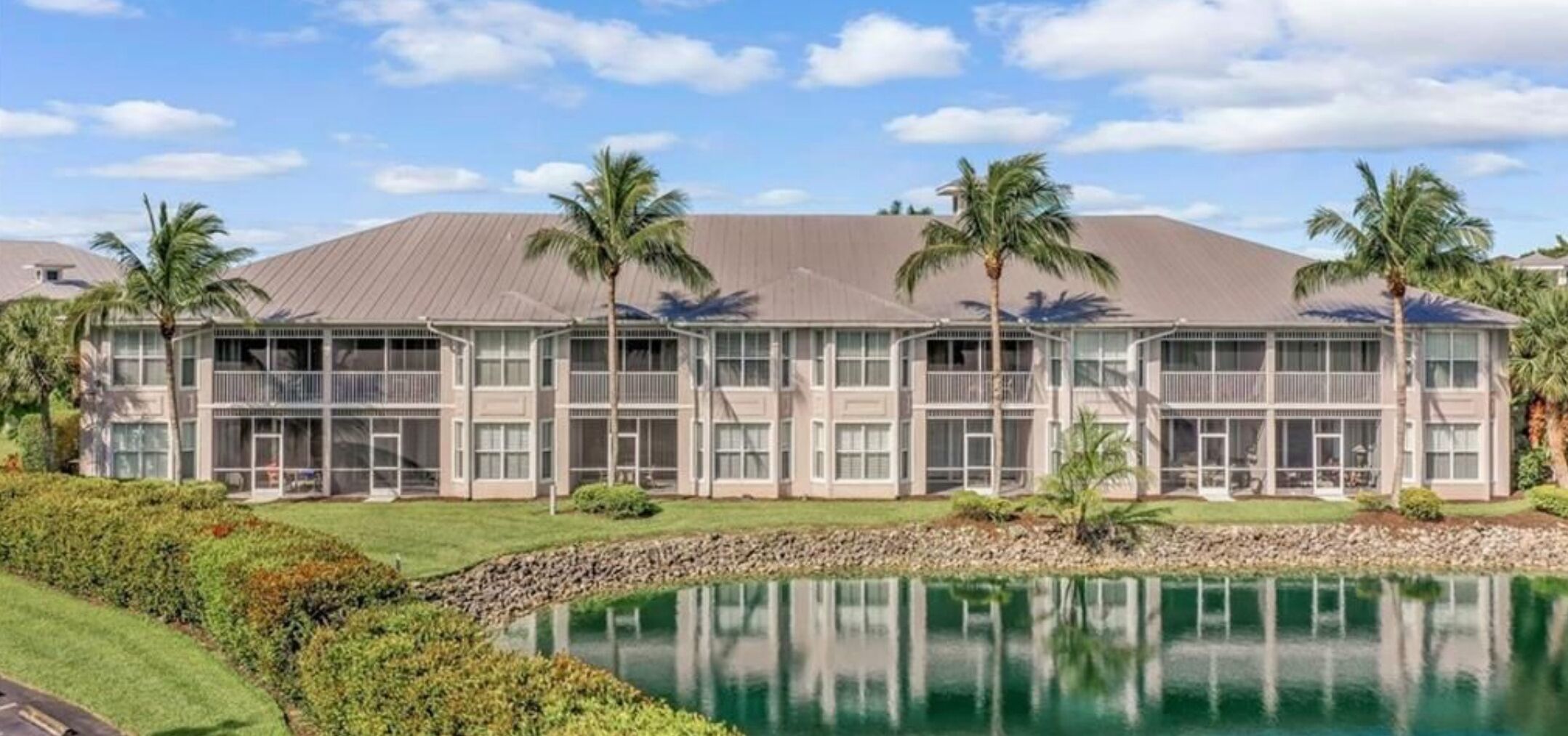 A large, multi-story hotel with a modern design, featuring a pool in the foreground and palm trees in the background.