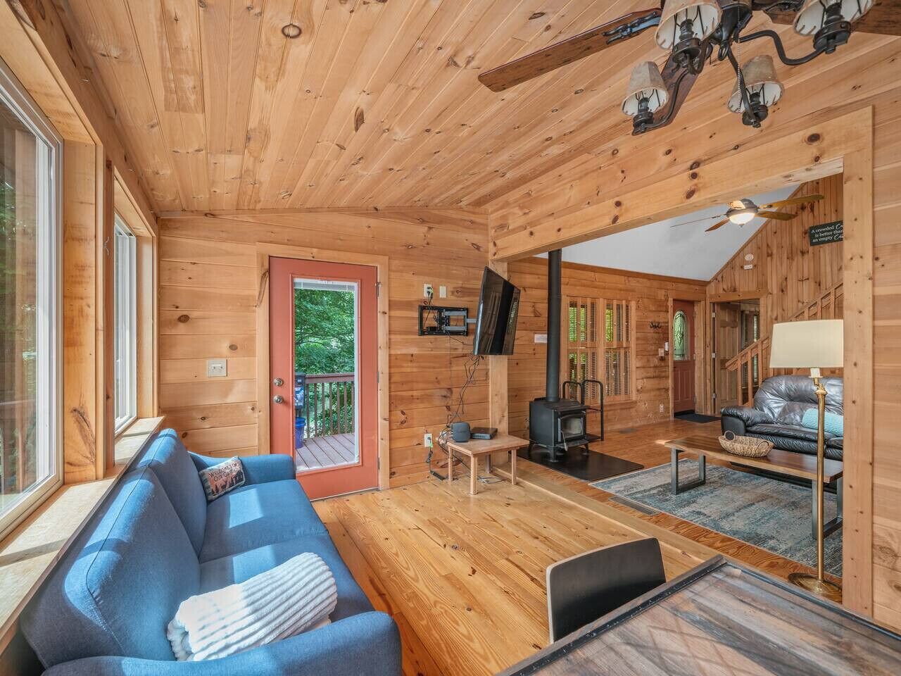 Ein Holzblockbau-Innenraum mit einer Couch, einem Fernseher und einem Kamin.