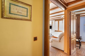 A room with a framed certificate on the wall, a wooden door, and a glimpse of a living area with a sofa and a table. - Apartment 'Zayda' with Balcony, Wi-Fi and Air Conditioning (Daroca)