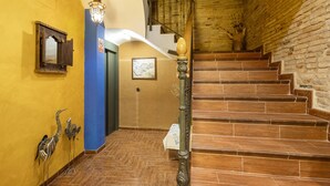 A staircase with wooden steps leading to a second floor, a wall-mounted light fixture, a blue wall, and a door with a sign. - Apartment 'Zayda' with Balcony, Wi-Fi and Air Conditioning (Daroca)