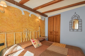 A bedroom with a bed, wooden wardrobe, wall-mounted mirror, and two wall sconces. - Apartment 'Zayda' with Balcony, Wi-Fi and Air Conditioning (Daroca)