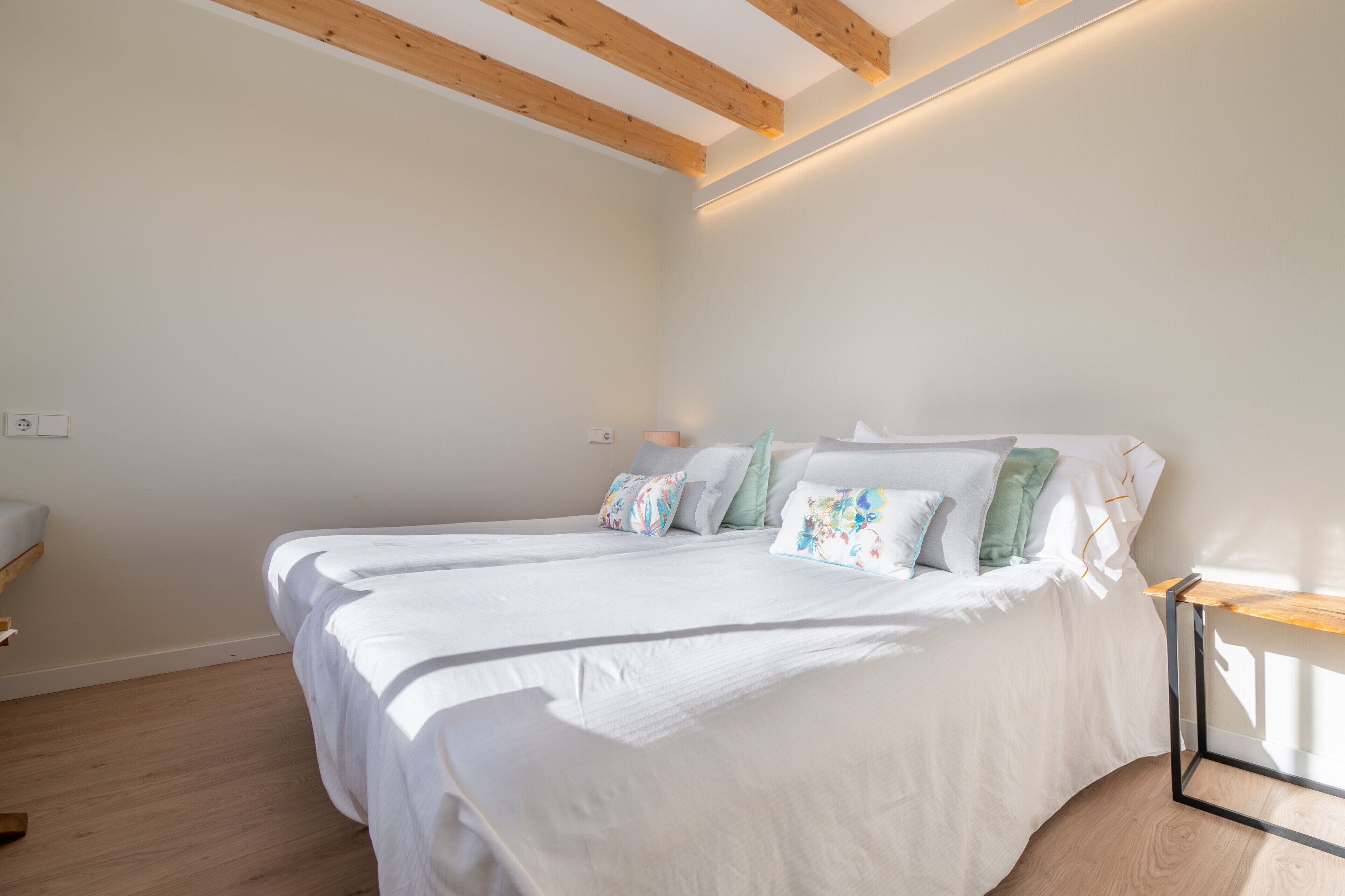 A bedroom with a bed, bedside table, and a nightstand.