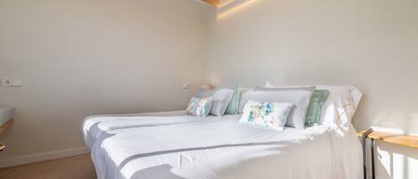 A bedroom with a bed, bedside table, and a nightstand.