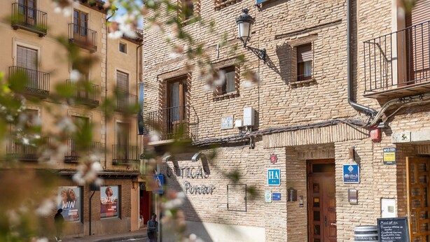 Un bâtiment en briques doté de nombreuses fenêtres, d’un lampadaire et de divers panneaux, dont un panneau indiquant un restaurant.