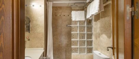 Un baño con ducha, inodoro y lavabo.