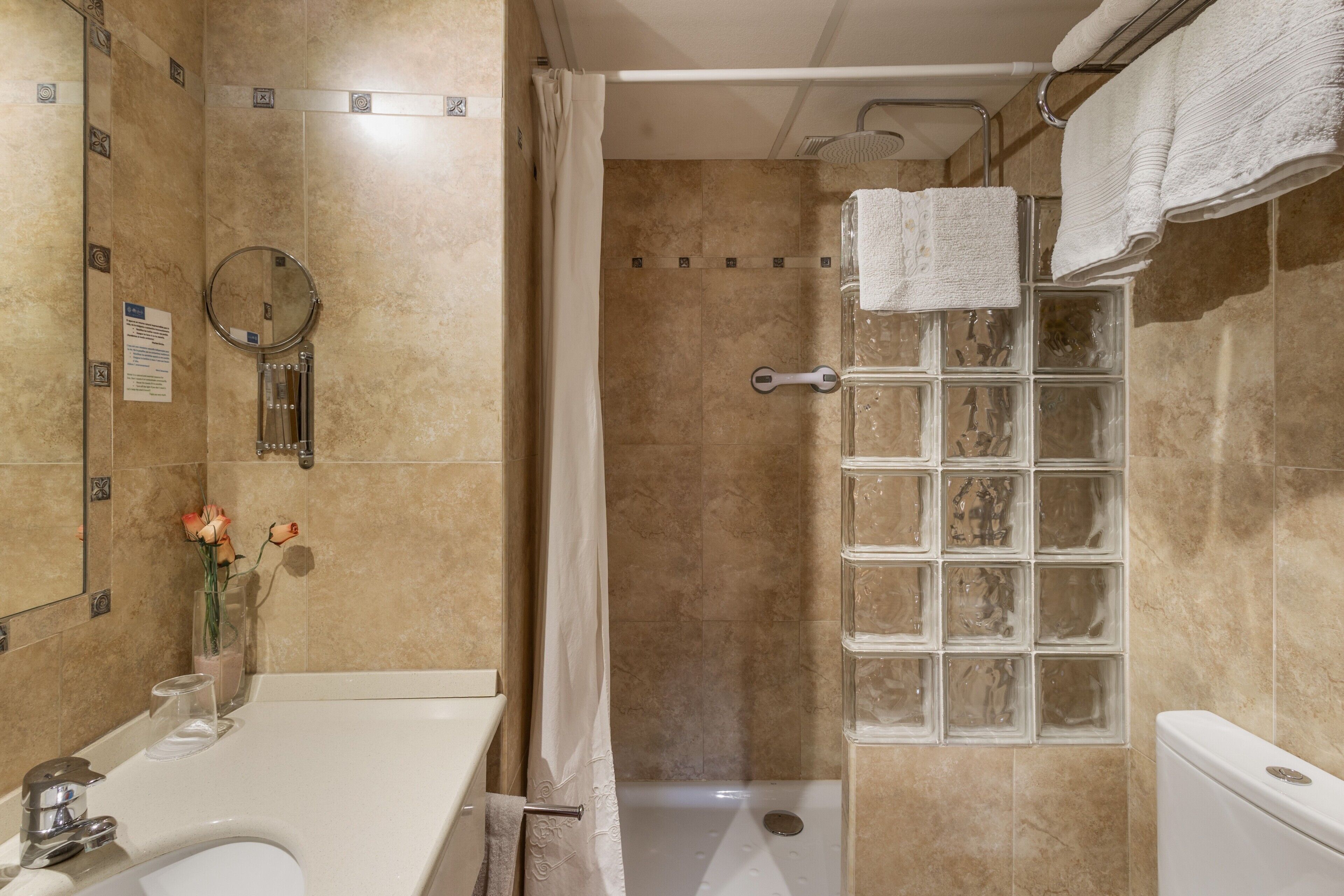 A bathroom with a shower, toilet, and sink.
