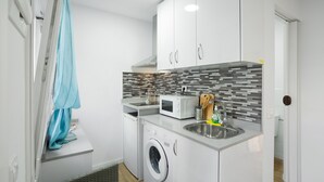 A compact kitchen with a washing machine, microwave, sink, and a tiled backsplash. - Vacation Studio 'Paula - 13' with Shared Pool, Shared Terrace and Wi-Fi (Arinaga)