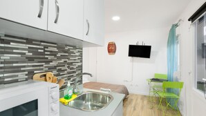 A compact kitchen with a microwave, sink, and wooden cutting board. - Vacation Studio 'Paula - 13' with Shared Pool, Shared Terrace and Wi-Fi (Arinaga)