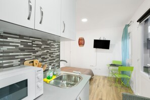A compact kitchen with a microwave, sink, and wooden cutting board. - Vacation Studio 'Paula - 13' with Shared Pool, Shared Terrace and Wi-Fi (Arinaga)