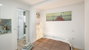 A bedroom with a bed, a painting, a shower, and a bathroom. - Vacation Studio 'Paula - 13' with Shared Pool, Shared Terrace and Wi-Fi (Arinaga)