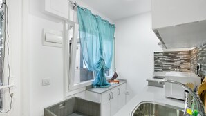 A compact kitchen with a sink, a window with a curtain, a wicker basket, and a microwave. - Vacation Studio 'Paula - 13' with Shared Pool, Shared Terrace and Wi-Fi (Arinaga)