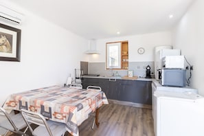 A compact kitchen with a dining area, a microwave, a sink, and a clock on the wall. - Family Holiday Home in Lubersac – Pond, Garden, Peace & Comfort (Lubersac)