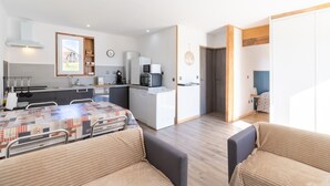 A modern kitchen with a dining area, a sofa, and a view of the outdoors. - Family Holiday Home in Lubersac – Pond, Garden, Peace & Comfort (Lubersac)