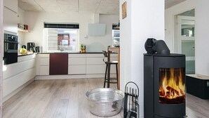 A modern kitchen with a central island, a stove, and a large metal bowl on the floor. - Elegant Blavand Getaway- By Traum Ferienwohnungen (Blavand)