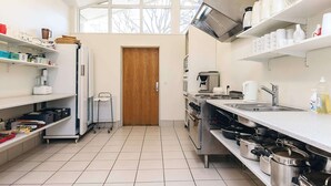 A modern kitchen with white cabinetry, a large window, and a stainless steel range hood. - 6 Person Holiday Park Home in Laeso (Læsø)