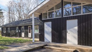 A modern building with a large garage door, a covered entrance, and a paved driveway. - 6 Person Holiday Park Home in Laeso (Læsø)