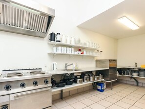 A kitchen with a stove, sink, and shelves with kitchenware. - 6 Person Holiday Park Home in Laeso (Læsø)