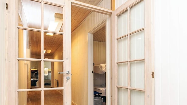 A wooden interior with a hallway leading to a room with a bunk bed and a trash bin. - 6 Person Holiday Park Home in Laeso (Læsø)