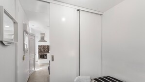 Een moderne hotelkamer met een bed, een badkamer met douche en een kitchenette.