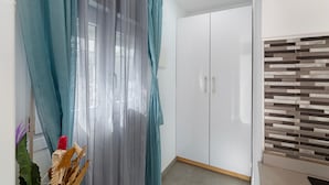 Een kamer met een garderobe, een gordijn en een muur met een decoratief patroon.