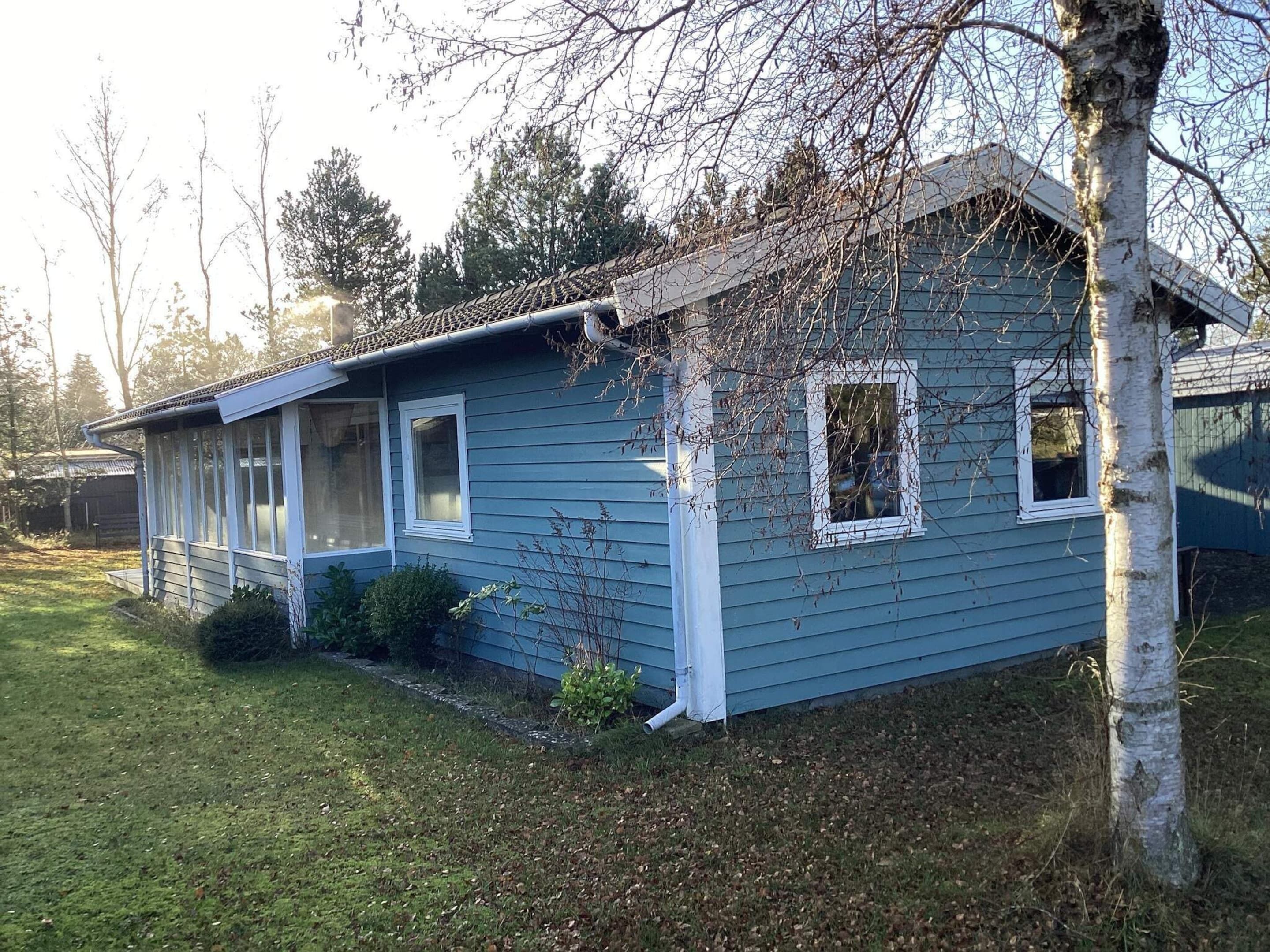 A single-story house with a gabled roof, a front porch, and a small front yard.