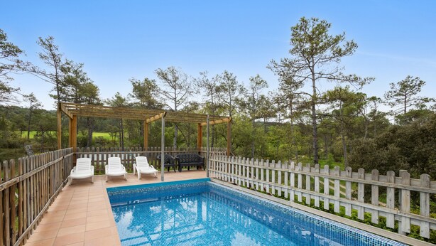 A rectangular pool with tiled edges, surrounded by a wooden deck and a white picket fence. - Rural House 'Cal Panxeta' with Mountain Views, Wi-Fi and Air Conditioning (Balsareny)