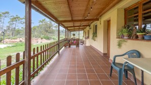 A covered patio with a wooden railing, a tiled floor, and potted plants. - Rural House 'Cal Panxeta' with Mountain Views, Wi-Fi and Air Conditioning (Balsareny)