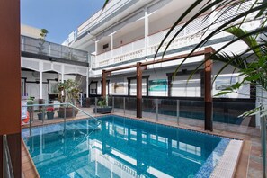 Una piscina interior con vista despejada a la arquitectura circundante, incluyendo un balcón y una escalera.