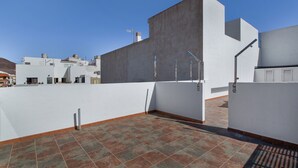 A rooftop terrace with a tiled floor, white walls, and a clear blue sky. - Vacation Studio 'Paula- 23' with Mountain View, Shared Pool and Wi-Fi (Arinaga)