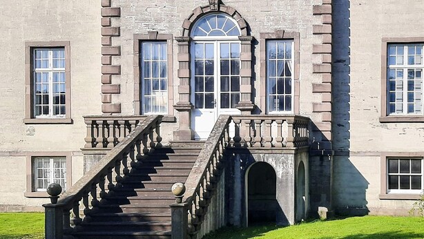 A large building with a central entrance, multiple windows, and a staircase leading to the entrance. - 9 Person Holiday Home in Mandal (Lindesnes)