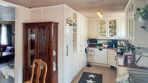A compact kitchen with white cabinets, a wooden chair, and a star-patterned rug. - 9 Person Holiday Home in Mandal (Lindesnes)