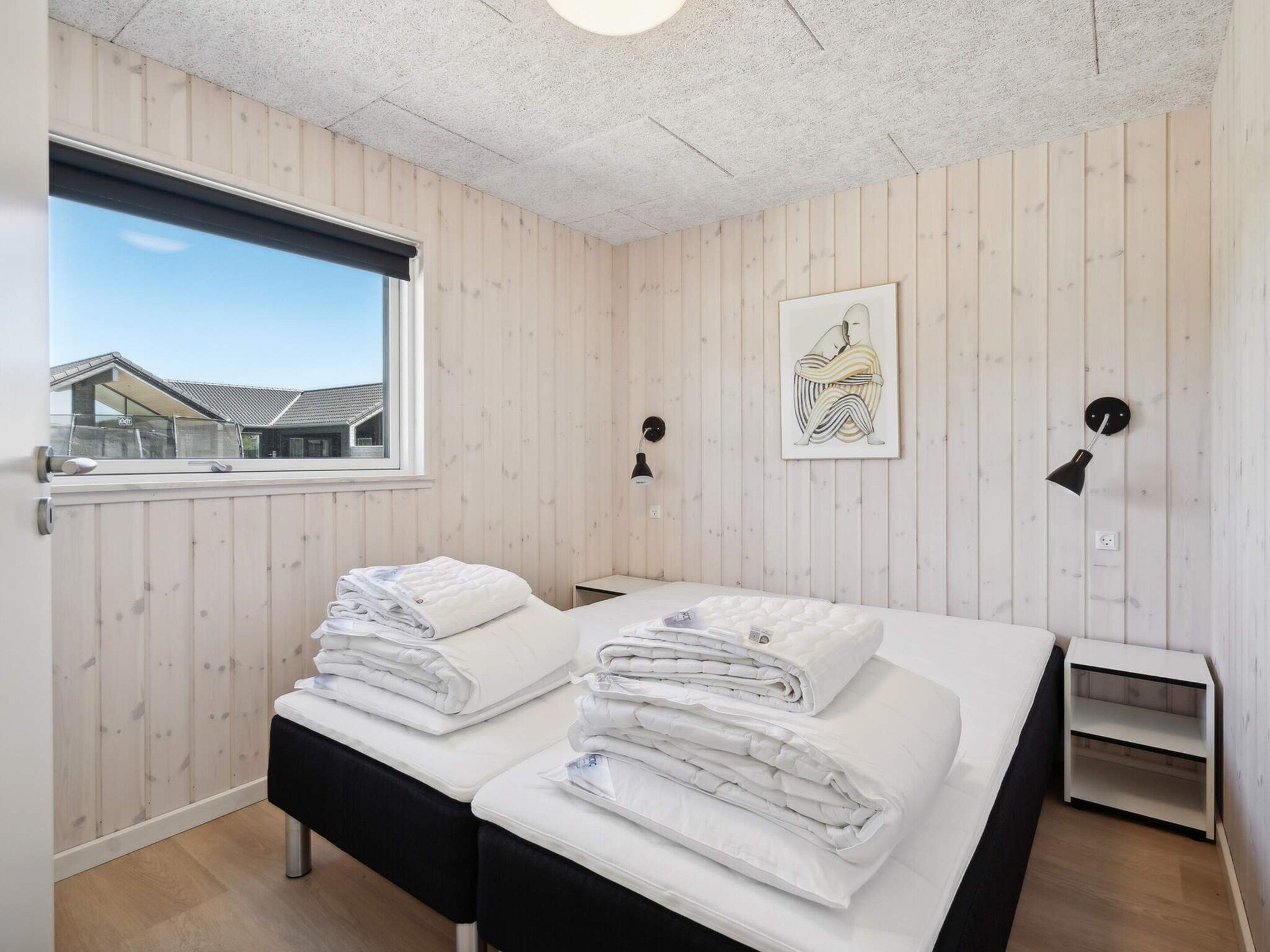 Una habitación de hotel con cama, mesitas de noche, una ventana y vistas al exterior.