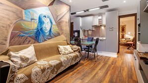 A modern living room with a sofa, a dining area, and a kitchen. - Apartment 'Buthier' with Mountain View, Balcony and Wi-Fi (Aosta)