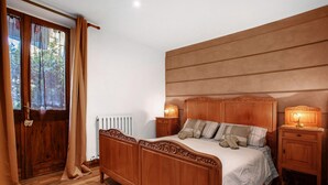 A wooden four-poster bed with a headboard, bedside lamps, and a nightstand. - Apartment 'Buthier' with Mountain View, Balcony and Wi-Fi (Aosta)