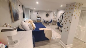 Une chambre moderne avec un lit, un bureau et une chaise. Un escalier mène à un autre niveau.